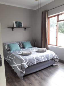 a bedroom with a large bed with blue pillows at Leisure@Loerie in Sedgefield