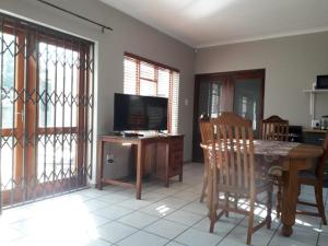 a living room with a table and a television at Leisure@Loerie in Sedgefield