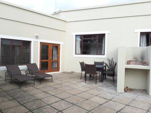 a patio with chairs and a table in a white house at Leisure@Loerie in Sedgefield