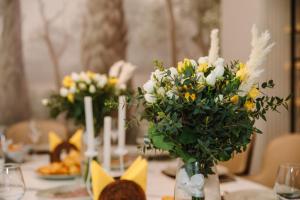 a table with yellow and white flowers in a vase at The Amsterdam Boutique Hotel in Aktobe +105 photos