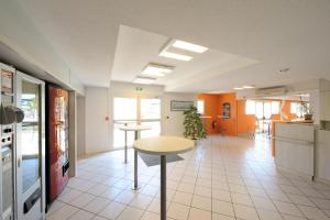 a kitchen with a table in the middle of a room at Hôtel Kennedy Parc des Expositions in Tarbes
