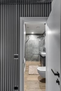 a bathroom with a shower and a toilet and a sink at Urban center apartment in Vilnius +11 photos