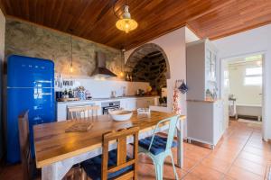 cocina con mesa de madera y nevera azul en Casa Luz, en Nordeste