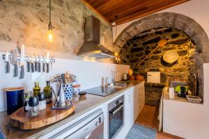 a kitchen with a counter and a stone wall at Casa Luz in Nordeste