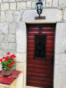 uma porta vermelha com um vaso de plantas e uma janela em Villa Sunrise em Herceg Novi