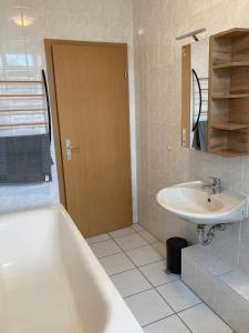 a bathroom with a bath tub and a sink at Ferienwohnung Zeitz Appartment Zeitzer Dom in Zeitz