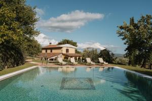 a swimming pool in front of a house at Terenzi Hospitality & Wine in Scansano