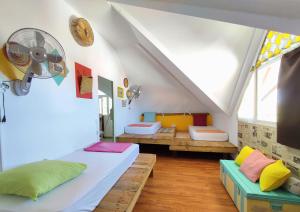 a room with two beds and benches in a attic at Ô PasSage - Kaz Auberge in Saint-Pierre
