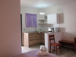 een keuken met een tafel, een stoel en een aanrecht bij Biscoutsis Apartments & Studios in Kavos
