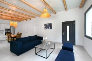 a living room with a blue couch and a table at DASÝLIO - earthy living homes in Ialysos