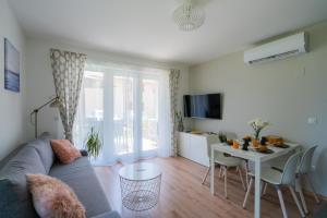 a living room with a couch and a table at Captain’s Home Kenese Apartman in Balatonkenese