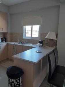 a kitchen with a counter and a table and a lamp at Universe House in Mor Menekshe +5 photos