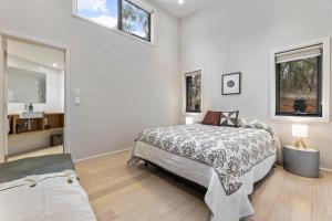 a bedroom with a large bed and a mirror at Benny's Retreat Luxury Bushland Escape in Clare
