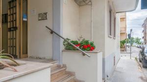 a pole on the side of a building with red flowers at Welcomely - Costa 7A in Alghero