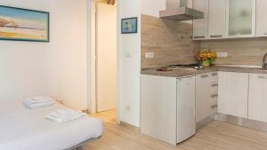a kitchen with white cabinets and a counter top at Welcomely - Costa 7A in Alghero