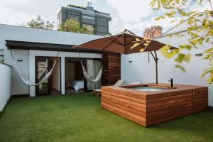 einen Hinterhof mit Whirlpool und Sonnenschirm in der Unterkunft Villaz Luxury Vacation Homes in Medellín