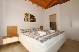 a white bedroom with a bed and a wooden ceiling at Sunset Sea View Villa 5 in Arillas