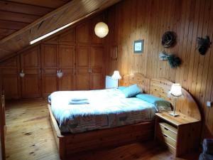 ein Schlafzimmer mit einem Bett in einem Holzzimmer in der Unterkunft Apartamento dúplex acogedor con piscina en Rialp in Rialp