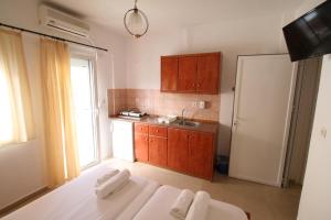a kitchen with a bed and a sink and a refrigerator at SARTI CENTER studios in Sarti