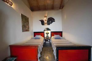 three beds in a room with red and white walls at Casa Buenavida in Alajeró
