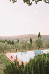 a swimming pool with a view of the hills at Castello Di Meleto Wine Destination - Camere in Castello e Appartamenti in Gaiole in Chianti