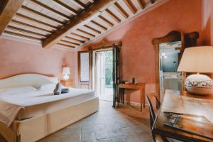 1 dormitorio con 1 cama y 1 mesa con lámpara en Terenzi Hospitality & Wine, en Scansano