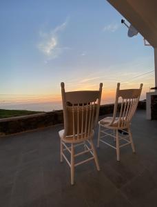 Dos sillas sentadas en un porche con vistas al océano en Casa da Ribeira do Além, en Angra do Heroísmo