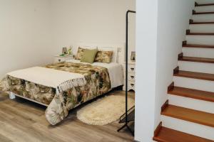 1 dormitorio con 1 cama al lado de una escalera en Casa da Ribeira do Além, en Angra do Heroísmo