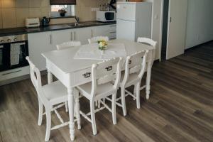una cucina con un tavolo bianco e sedie bianche di Casa da Ribeira do Além ad Angra do Heroísmo Altre 7 foto