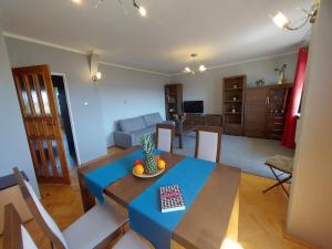 a dining room and living room with a table and chairs at Wygodny Przestronny Apartament Janowskie Błonia Rumia in Rumia