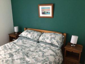 a bedroom with a bed and two night stands with two lamps at Victoria Cottage in Reeth