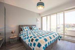 a bedroom with a bed and a large window at Les Vagues in Courseulles-sur-Mer