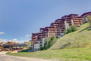a building on top of a hill next to a dirt road at Les Valmonts 711 in Les Menuires