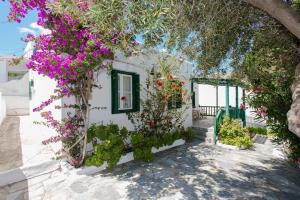 a white building with flowers on it at Charming House Platy Gialos in Platis Yialos Mykonos
