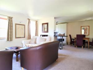 un soggiorno con divano e tavolo di Wellstone Cottages - Honeysuckle a Llanfyrnach