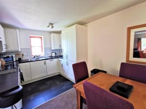 a kitchen and dining room with a table and chairs at Wellstone Cottages - Honeysuckle in Llanfyrnach +25 photos