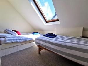 two beds in a room with a window at Wellstone Cottages - Honeysuckle in Llanfyrnach