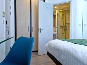 1 dormitorio con 1 cama y 1 silla azul en 146 Studios, en Londres