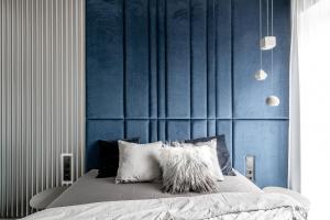 a bedroom with a bed with a blue wall at Urban center apartment in Vilnius