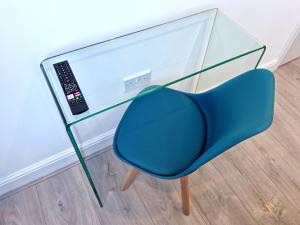 einem blauen Stuhl unter einem Glastisch mit Fernbedienung in der Unterkunft 146 STUDIOS Regent's Park in London
