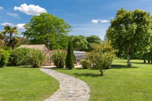 Saint-Androny的住宿－達吉恩宅邸酒店，树木和建筑公园中的石头路径