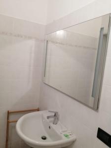 ein weißes Badezimmer mit einem Waschbecken und einem Spiegel in der Unterkunft Casa Vincenzo in Bologna