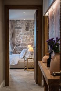 a bedroom with a bed and a stone wall at Apartments Hun in Kotor