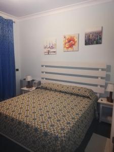 1 dormitorio con 1 cama y algunas fotos en la pared en B&b kabbala club, en Lattarico