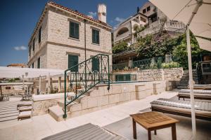 un patio con una mesa y una sombrilla y un edificio en Villa Allure of Dubrovnik en Dubrovnik