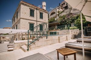 patio ze stołem, parasolem i budynkiem w obiekcie Villa Allure of Dubrovnik w Dubrowniku