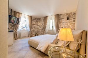 a bedroom with a bed and a table with a lamp at Apartments Hun in Kotor