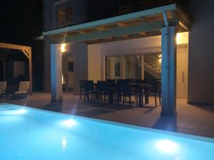 basen w pokoju ze stołem i krzesłami w obiekcie Sunset Sea View Villa 5 w mieście Arillas