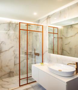 La salle de bains blanche est pourvue d'un lavabo et d'une douche. dans l'établissement Erofili Hotel & Suites, à Portariá