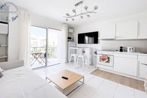 sala de estar blanca con sofá blanco y cocina en Sunny Noa's apartment double pool view- wifi fibra by Rentalfue, en Corralejo